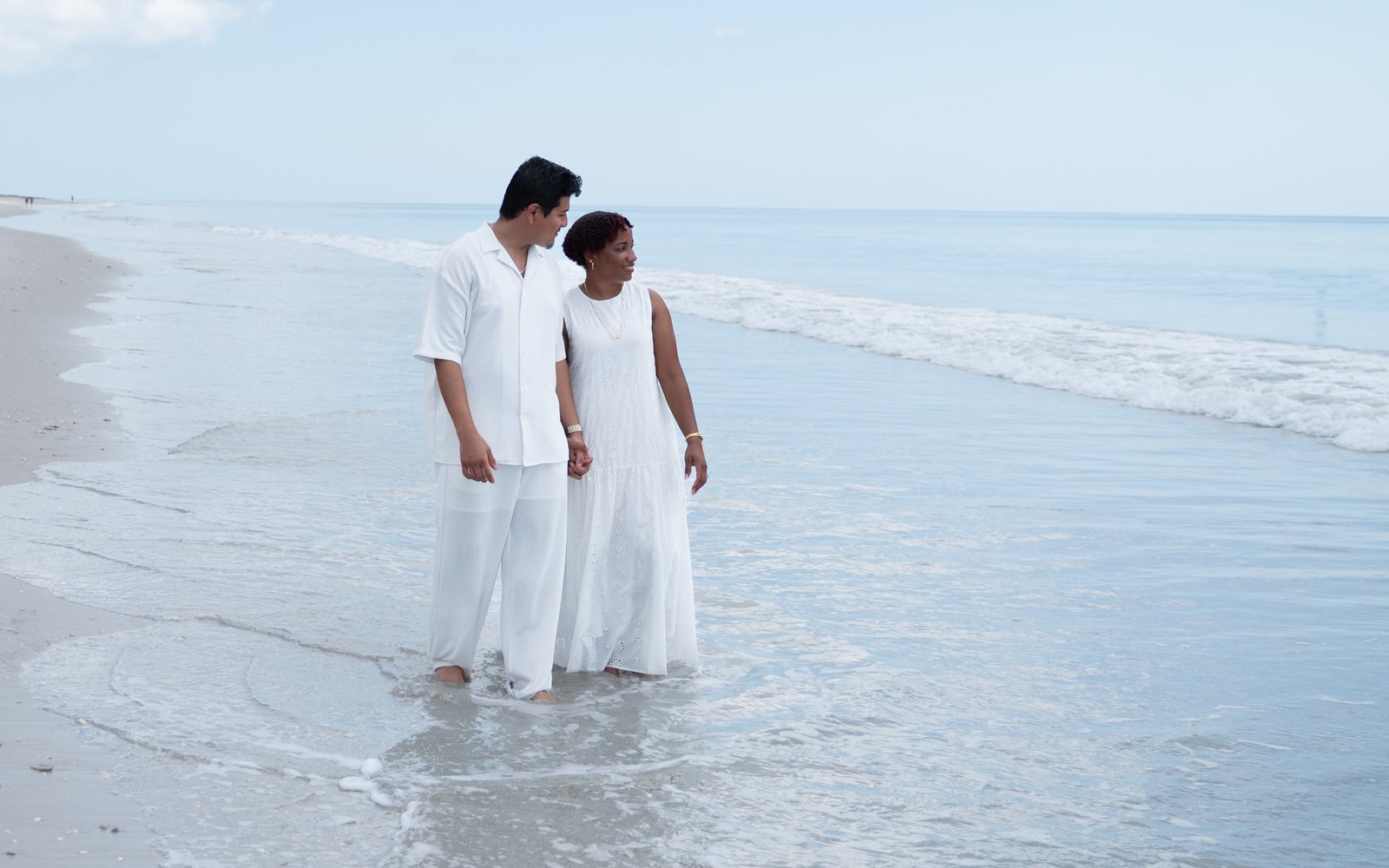 Josue and Yassiel walking hand in hand along the shore